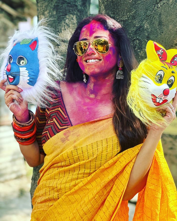 হলুদ শাড়ি, গোটা মুখে ভর্তি রং। দুই হাতে দুটো মুখোশ নিয়ে পোজ দিলেন সোহিনী সরকার।