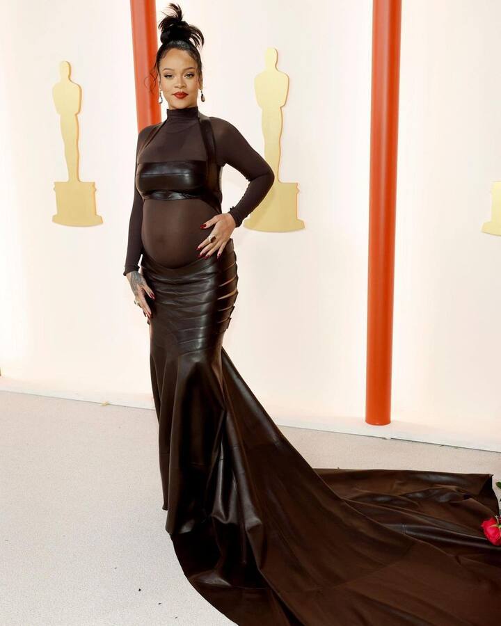 Rihanna, who is one of the performers at Oscars 2023, took the centre stage in a stunning black outfit that featured her baby bump in all its glory. She went ahead with a high bun and red lipstick to complement her black outfit.