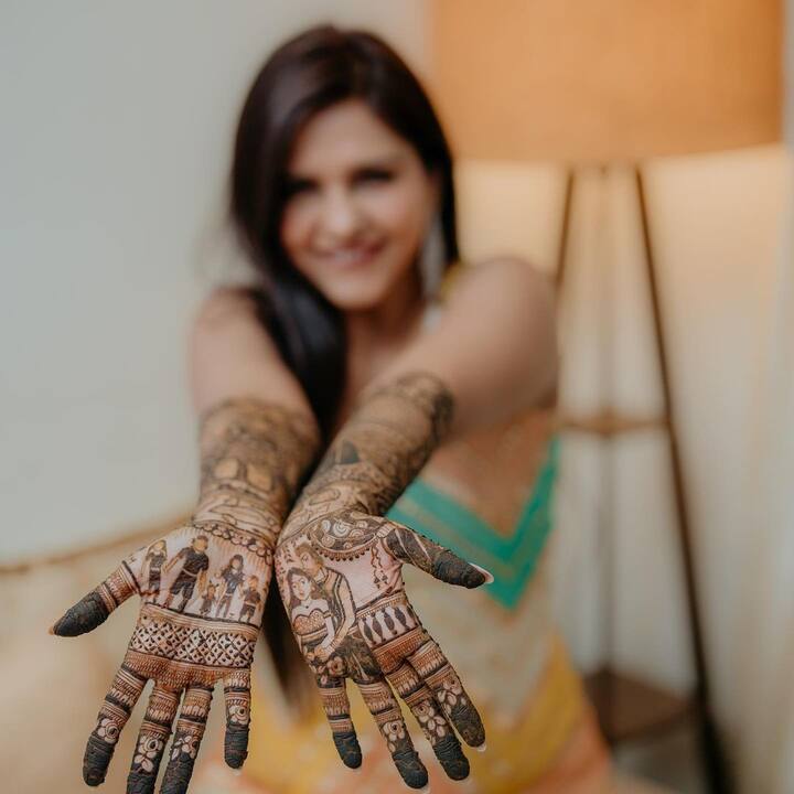 Her mehendi design has the bride and groom on one hand, and the other hand has the complete family including her son Jaydon and Nikhil's two daughters from his previous marriage.