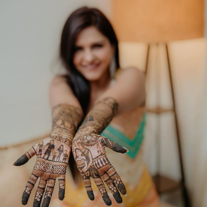 Her mehendi design has the bride and groom on one hand, and the other hand has the complete family including her son Jaydon and Nikhil's two daughters from his previous marriage.