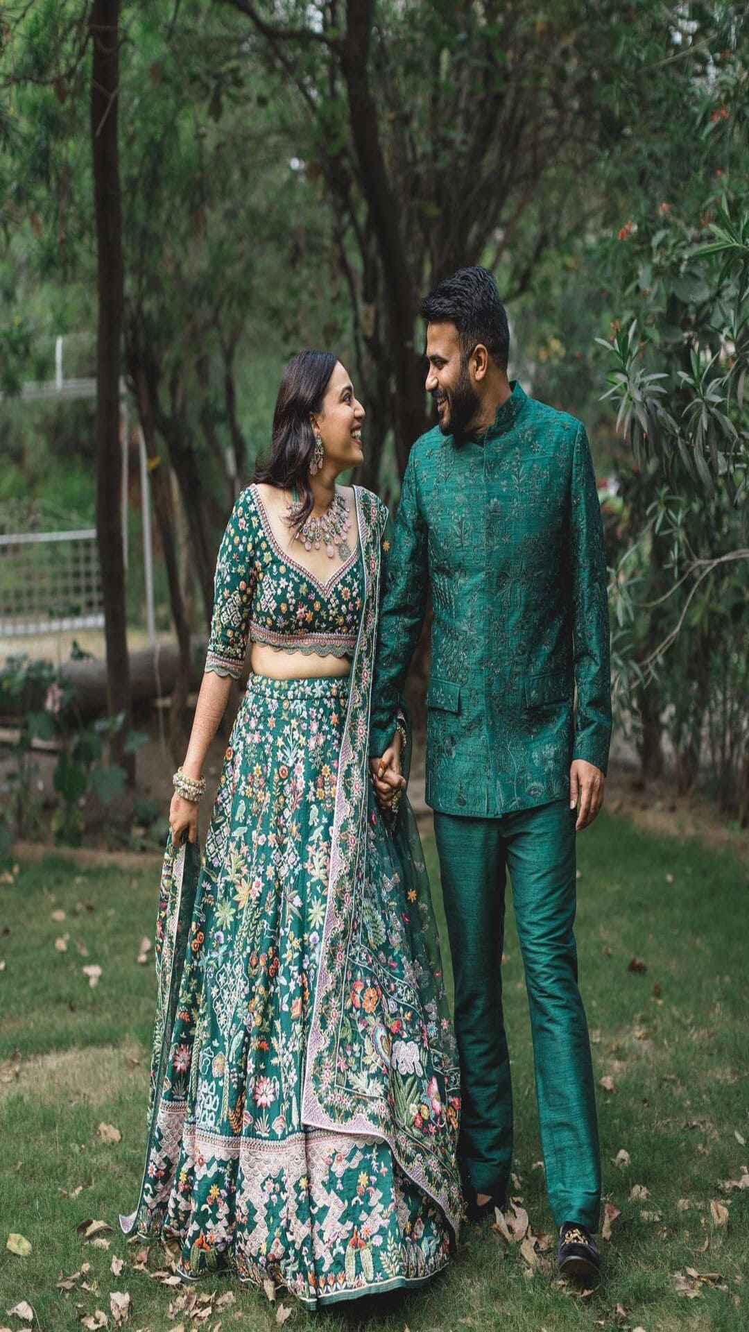 Photo of matching bride and groom in green outfits for their mehendi