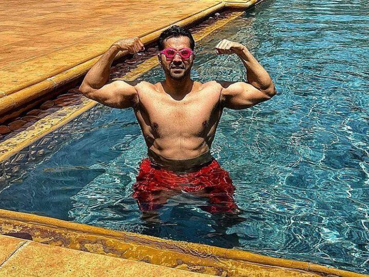 Varun dhawan trolled for latest pics netizens called him over acting ki dukaan Varun Dhawan Pics: स्वीमिंग पूल में बॉडी दिखाने पर ट्रोल हुए वरुण धवन, यूजर्स बोले- 'ओवर एक्टिंग की दुकान'
