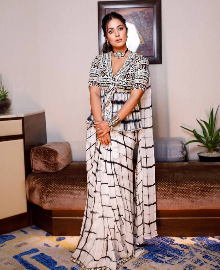 अगर गर्मियों के मौसम में आप साड़ी पहनना चाहते हैं और ज्यादा हैवी लुक नहीं अपनाना चाहते, तो इस तरह की कॉटन व्हाइट और ब्लू चेक्स वाली साड़ी कैरी कर सकते हैं. उसके साथ पेप्लम स्टाइल ब्लाउज बेहद स्टनिंग लगेगा. अपने स्टाइल को पूरा करने के लिए आप हिना खान की तरह जंक ज्वेलरी पहन सकते हैं.