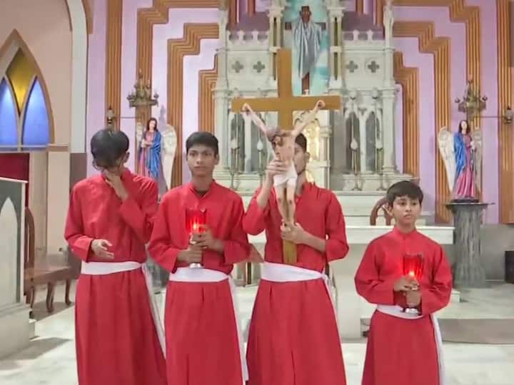 Altar boys holding a cross during mass at St. Teresa's Church on the occasion of Good Friday.