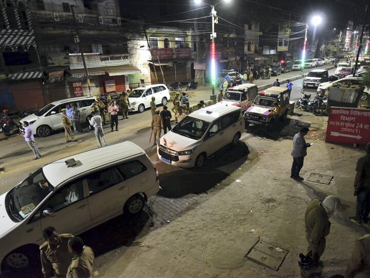 Police personnel at the crime scene where mafioso-turned-politician Atiq Ahmed and his brother Khalid Azim aka Ashraf were shot dead while being taken for medical checkup to a hospital, in Prayagraj, Sunday, April 16, 2023.