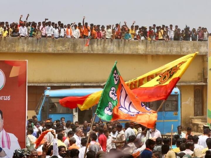 People waved BJP's flag during the roadshow in Karnataka's Shiggaon district. (Photo: Twitter/JP Nadda)