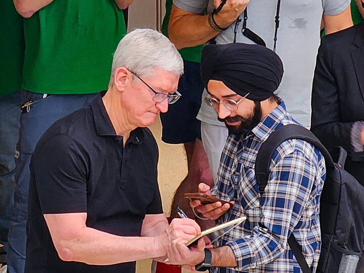 Apple CEO Tim Cook signs an autograph for a customer at the opening of India's second Apple retail store at Saket in New Delhi, Thursday, April 20, 2023.