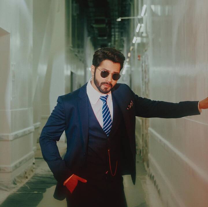 Varun looks quite fashionable with his blue pantsuit, white shirt, and pinstriped tie.