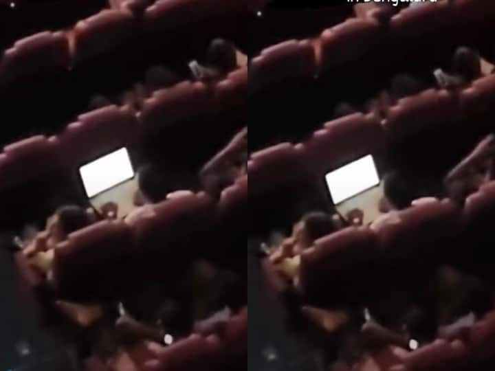 Man working on laptop in theatre Bengaluru viral video पिक्चर हाॅल में फिल्म देखते हुए लैपटॉप पर काम कर रहा शख्स, Video देख लोग बोले- Work From Theatre