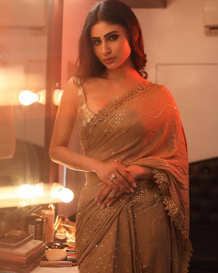 Mouni left her tresses open styled into soft waves and went in for smoky eyes.