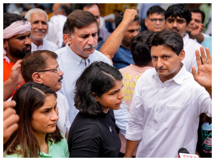 Congress leader Deepender Singh Hooda with wrestlers Vinesh Phogat and Sakshi Malik during their protest at Jantar Mantar, in New Delhi on Friday. (Image: PTI)