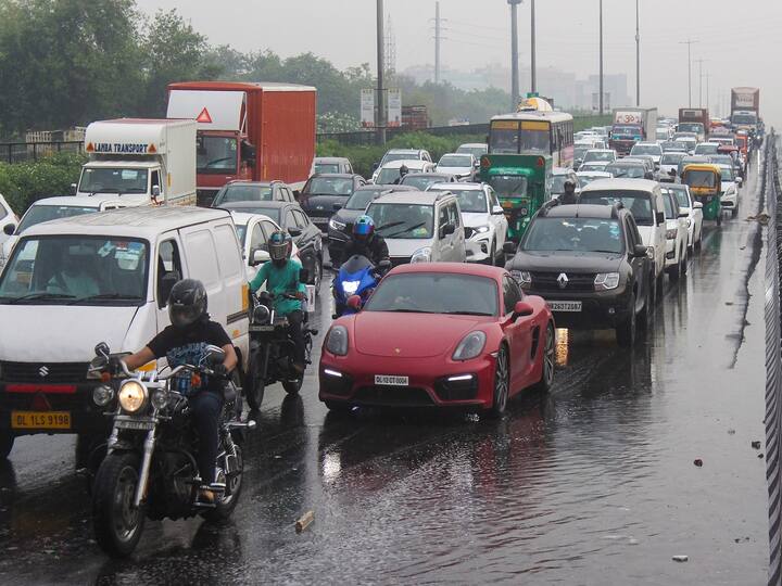 The rain, without a doubt, lowers the temperature; it also brings with it long traffic jams. The image depicts vehicles stuck in traffic on the Delhi-Gurugram Expressway due to rain. (Image Source: PTI)