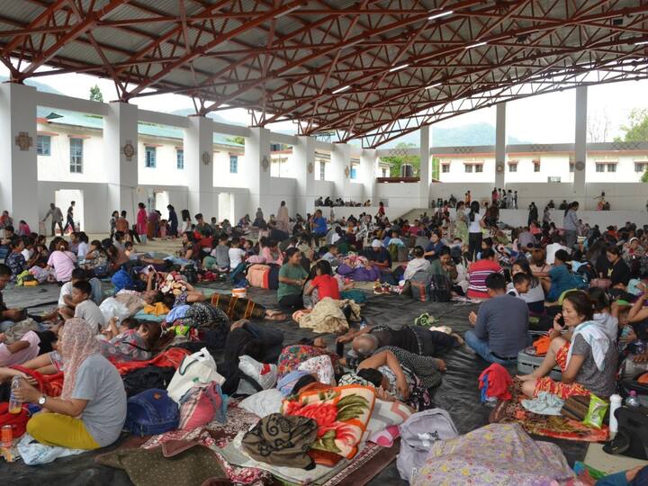 Evacuated people from various areas of Manipur resting under a temporary shelter.