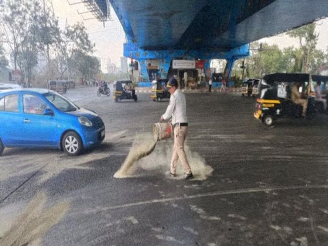 Mumbai Cop Sprinkles Sand On Slippery Road To Prevent Accidents, Earns Praise From Netizens Mumbai Cop Sprinkles Sand On Slippery Road To Prevent Accidents, Earns Praise From Netizens