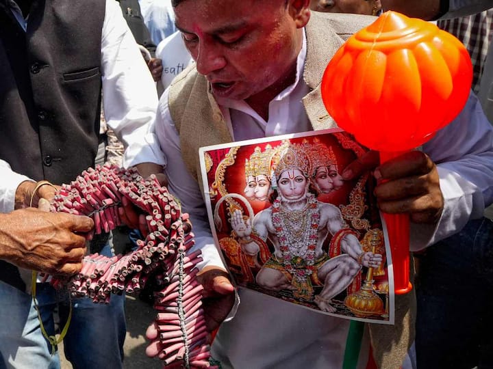 Jubilant Congress supporters were displaying lord Hanuman’s images while bursting crackers as part of celebrations for their victory in the Karnataka elections. (Source: PTI)