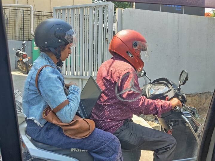 Bengaluru women working in traffic jam photo went viral social media users reacted ट्रैफिक जाम में फंसी महिला ने बाइक पर ही शुरू कर दिया ऑफिस का काम, लोग बोले- 'खुद के लिए भी टाइम निकालो'