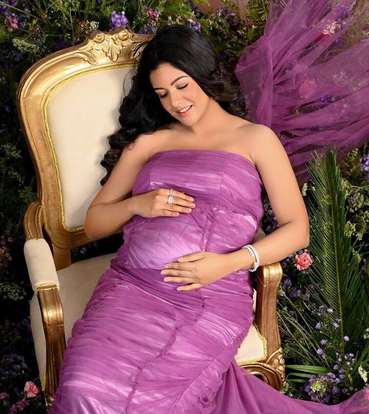 In the photos, she is seen caressing her growing baby bump while wearing her hair in beautiful curls.
