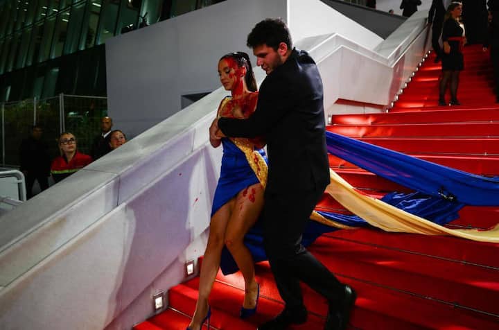 Protester Dressed In Ukrainian Colours Covers Herself In Fake Blood On Cannes Red Carpet Cannes Film Festival: 'खून से लथपथ' होकर कान्स फिल्म फेस्टिवल में पहुंची महिला, लोग देख रह गए हैरान
