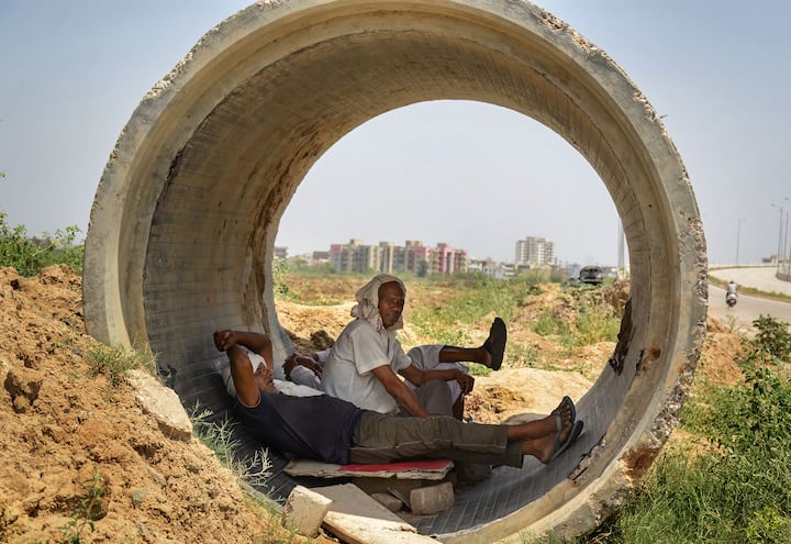 दुपारच्या उन्हापासून संरक्षण मिळवण्यासाठी अश्या प्रकारे लोकांना मिळेल तो सहारा घ्यावा लागत असल्याचे जागोजाग पाहायला मिळते (Photo:PTI)