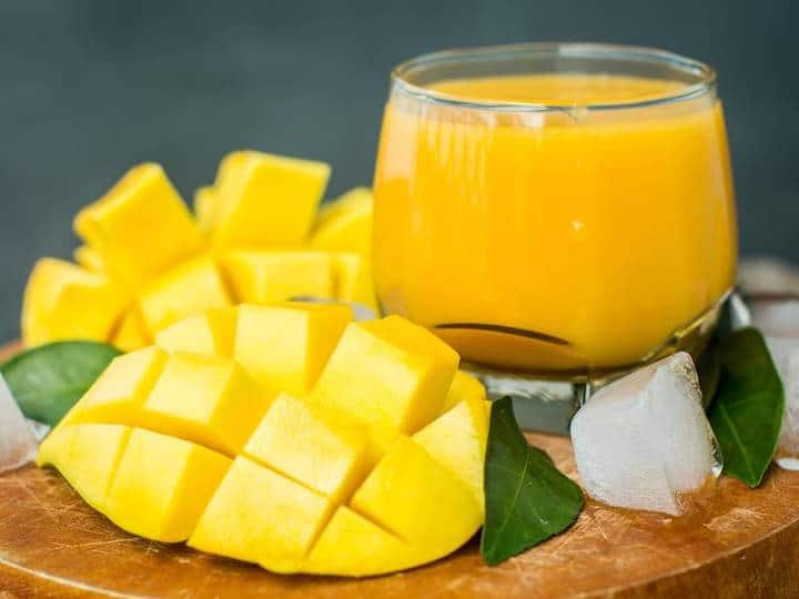 आम और पुदीने की पत्तियों को ठंडे बहते पानी में धो लें. अब आम को छीलकर स्लाइस में काट लें. इसके बाद इन कटे हुए आमों को दही, दूध, इलायची, संतरे के रस, शहद और बर्फ के क्यूब्स के साथ एक ब्लेंडर जार में डालें. अच्छी तरह से पिस जाए इसलिए ब्लेंड करते रहें.