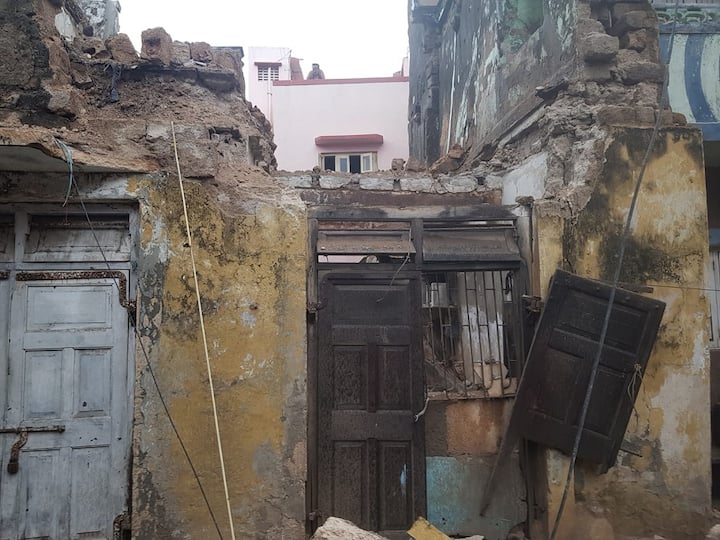 A house collapsed in Porbandar due to the impact of Cyclone Biparjoy. Cyclone Biparjoy : પોરબંદરમાં વિનાશની શરૂઆત, ચોપાટી પરનો પાળો તૂટ્યો , મકાન ધરાશાયી થતાંં એકનું મોત