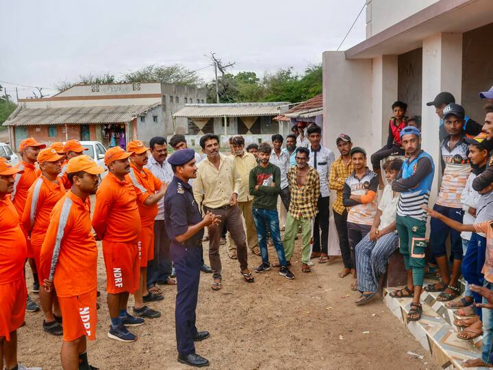 National disaster response force (NDRF) personnel brief citizens ahead of cyclone Biparjoy's landfall, at Mandvi, in Kutch. (Photo: PTI)