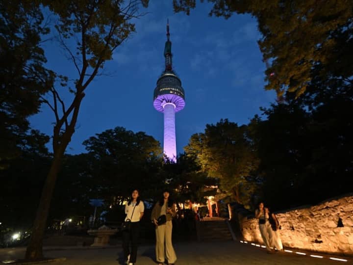 The landmark Namsan Seoul Tower was illuminated purple to mark the 10-year anniversary of the famous K-pop band BTS. Image Source: Getty Images