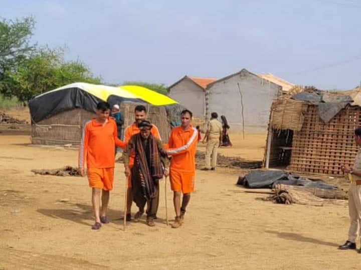 NDRF personnel assist a villager during evacuations as part of safety measures on Wednesday. NDRF, in collaboration with the state government, has deployed 18 teams primarily in Kutch. (Image Source: PTI)