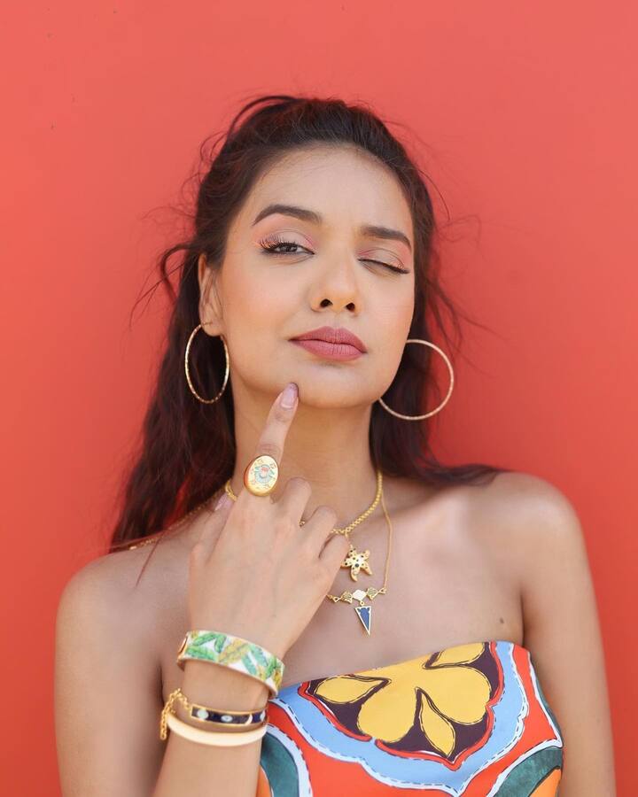 Additionally, she also wore huge hoop earrings and paired her outfit with a couple of colourful wrist bands and rings on her fingers.(Image Source: Instagram/Divya Agarwal)