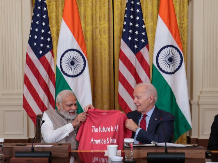 Prime Minister Narendra Modi and US President Joe Biden hold a t-shirt which reads 'The future is AI'.