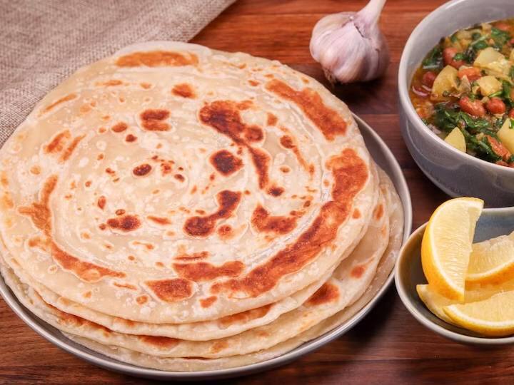 नरम आटा गूंथ लें और रोटी बेलकर उसमें स्टफिंग भर दें. एक बड़े मिश्रण के कटोरे में गेहूं का आटा डालें. धीरे-धीरे पानी डालकर नरम आटा गूंथ लें. आटे की छोटी-मध्यम लोइयां बनाकर 3 से 4 इंच के गोले में बेल लीजिए. बीच में एक चम्मच आलू की फिलिंग डालें. परांठे बनाते समय बेलन को धीरे-धीरे चारों तरफ से दबाएं. समान रूप से दबाव डालने के लिए बहुत सावधान रहें. यह सुनिश्चित करना बहुत महत्वपूर्ण है कि आपका आलू का मिश्रण अच्छी तरह से मैश किया हुआ हो और गांठदार न हो, अन्यथा आप कभी भी परफेक्ट परांठा नहीं बना पाएंगे. आटे को सील कर उंगलियों से गोल कर लीजिए. अब इन्हें बेलन की सहायता से गोल परांठे के आकार में बेल लें. सभी तरफ बहुत समान रूप से और धीरे से दबाव डालें. बहुत हल्का दबाएं ताकि मिश्रण बाहर न निकले.