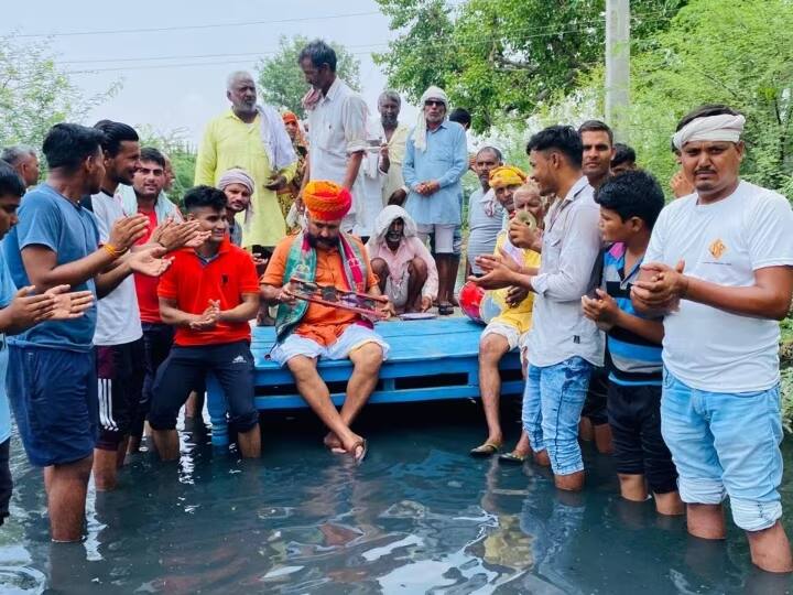 Bharatpur Villagers demonstrated by sitting in water on main road Rajasthan ann Bharatpur News: मुख्य सड़क पर जलभराव पर ग्रामीणों का अनूठा प्रदर्शन, पानी में बैठककर किया भजन कीर्तन