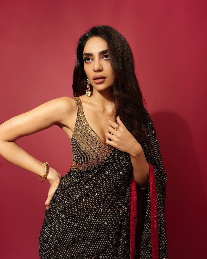 The actress paired a low-cut golden and black blouse with her saree.