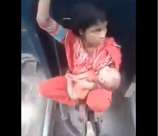 Viral Video: Woman made painful journey between two coaches of train with child Viral Video: મહિલાએ બાળકને ખોળામાં લઈ ટ્રેનના બે ડબ્બા વચ્ચે કરી દર્દનાક મુસાફરી, ડરામણો વીડિયો જોઈ લોકો સ્તબ્ધ