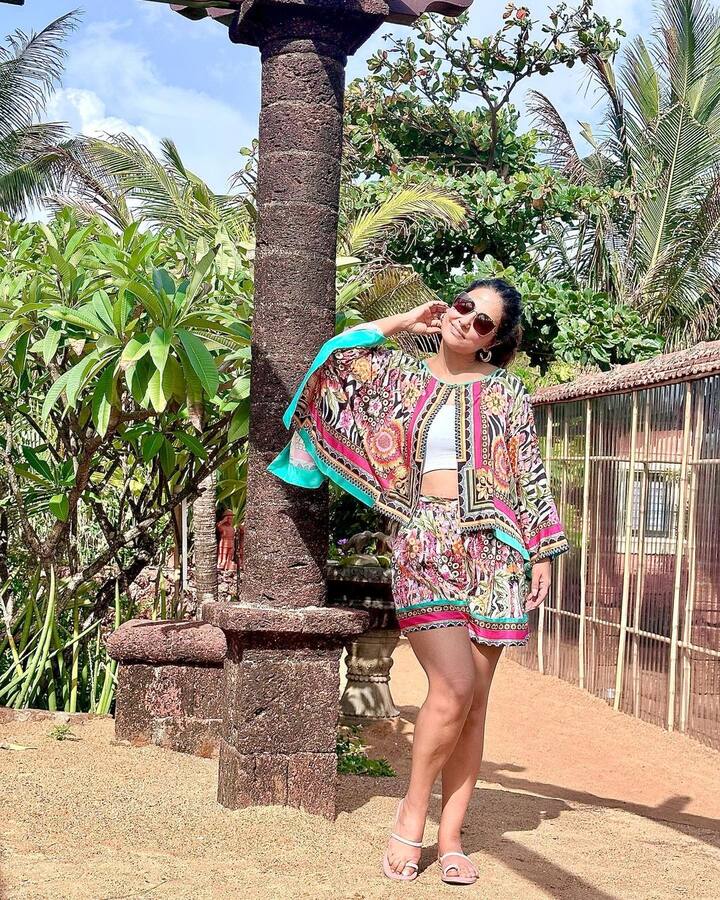 Hina shared pictures where she can be seen in a multi-coloured outfit comprising a white top, a printed Kaftan shrug and matching shorts. (Image Source: Instagram/Hina Khan)