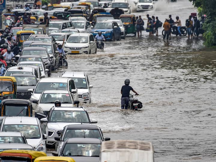 Commuters have been facing a hard time after traffic was diverted due to waterlogging at the ITO road, a key stretch connecting east Delhi to Lutyens' Delhi. Some people were seen dragging their vehicles on the waterlogged road. (Image Source: PTI)