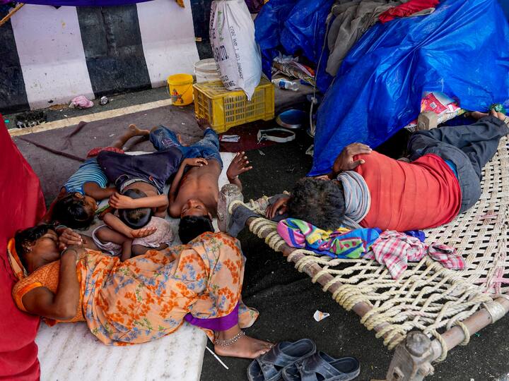 People rest under a makeshift tent in the Mayur Vihar area after it was flooded by the Yamuna. The Central Water Commission's (CWC) data, on Saturday, showed the water level receding to 205.29 m at 9 am. On Friday, the water level had crossed the danger level of 205.33 m. (Image Source: PTI)