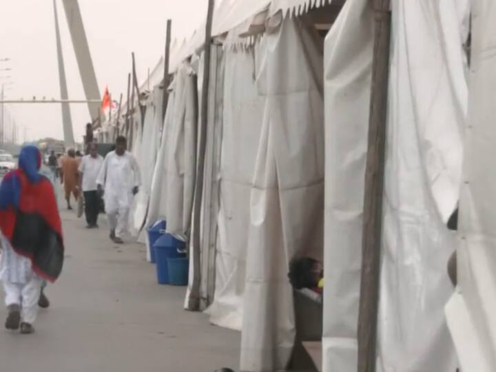 People walk by the tents set up on the Signature Bridge in New Delhi for the relief camp set up for flood-hit people. (Image Source: ANI)