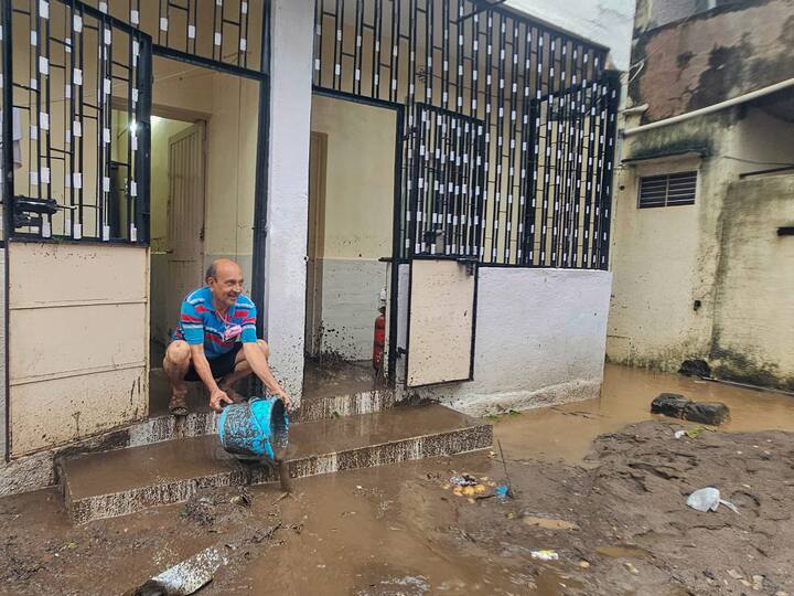 A man removes mud from his house after heavy monsoon rains, in Junagadh. The India Meteorological Department (IMD) has issued a warning of heavy to very heavy rainfall with isolated extremely heavy rainfall in south Gujarat and Saurashtra-Kutch districts till Sunday morning. (Image Source: PTI)