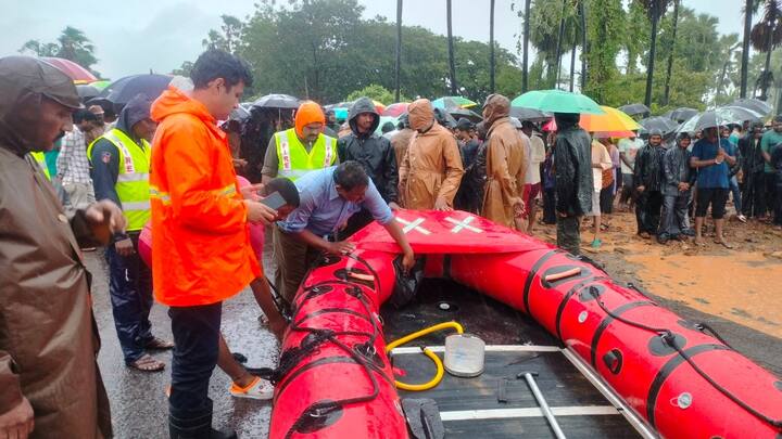 పడవలను తీసుకొని వరదల్లో మునిగిపోయిన గ్రామంలోకి వెళ్తున్న సిబ్బంది