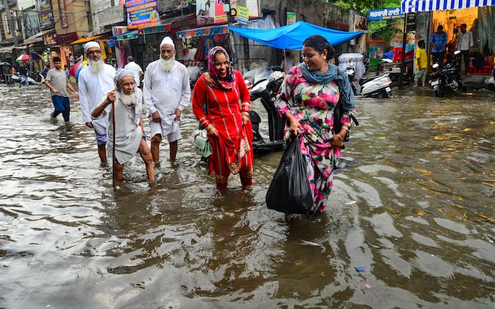 Jalandhar: पंजाबमधील जालंधर.. जालंधर या शहराच्या नावाचा प्राचीन अर्थ पाण्यात वसलेलं शहर असाच आहे. जुलै महिन्यातील पावसाने शहराच्या नावाचा प्राचीन अर्थ सार्थ केलाय.. सतलज आणि बियास नदीच्या खोऱ्यात वसलेल्या जालंधरला जुलै महिन्यातील पावसाने पाण्याने पूर्णपणे वेढून टाकलं. हा फोटो वीस जुलै रोजीचा आहे. मुसळधार पावसाने शहरातील मार्केटचा परिसर जलमय झाला. सर्वसामान्यांना कमरेइतक्या पाण्यातून वाट काढत दैनंदिन कामे उरकावी लागली. (PTI Photo)