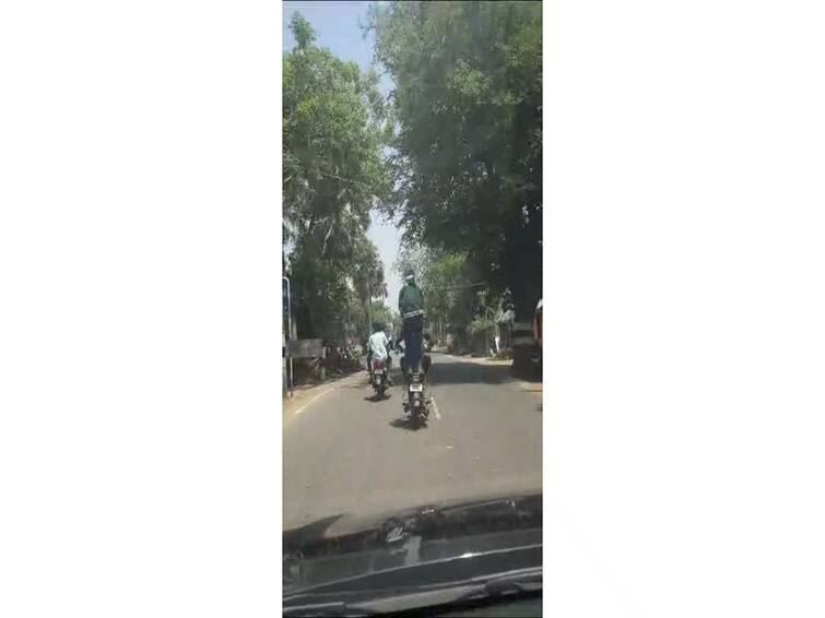 Thiruvarur near youngsters Adventure on a bike There is a stir in Tiruvarur TNN பைக்கில் ஏறி நின்று சாகசம்; திருவாரூரில் அச்சுறுத்திய வாலிபரால் பரபரப்பு