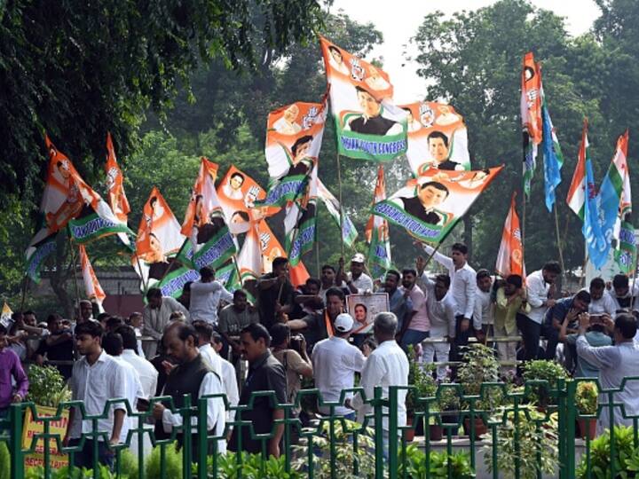 Jubilant Congress party workers wave party flags and celebrate after the Supreme Court stayed Rahul Gandhi's conviction. (Source: Getty)