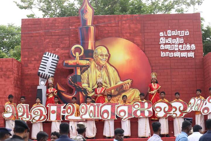 தமிழ் உயிர் எழுத்துகளின் பதாகையை ஏந்தி நிற்கும் சிறு பிள்ளைகளின் புகைப்படம்.