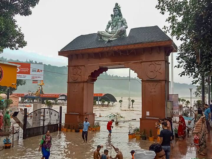 Devotees at the flooded Triveni Ghat after the water level of Ganga river rose due to monsoon rains, in Rishikesh. (Photo: PTI)