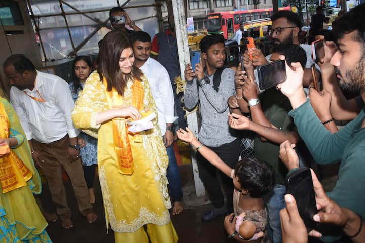 સિદ્ધિ વિનાયક મંદિર પાસે ગરીબ બાળકોને મીઠાઈનું વિતરણ કરતી કૃતિ સેનન.