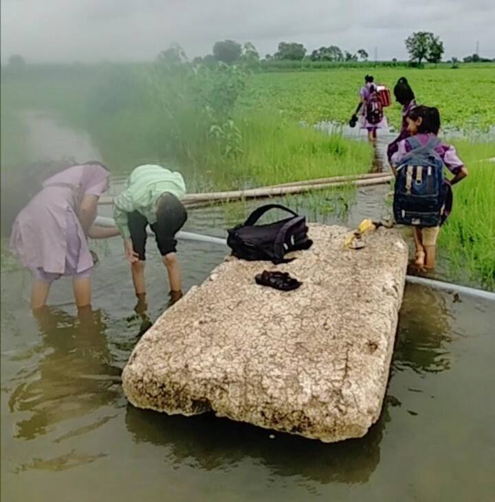 धरणाच्या बॅकवॉटरमधून सडलेल्या थर्माकोलच्या तराफ्यावर बसून एक किलोमीटरचा प्रवास केल्यावर हा संघर्ष थांबत नाही. कारण नदीपात्रातून बाहेर पडताच घनदाट गवत आणि एक फूट पाण्यातून तब्बल दोन किलोमीटर पायपीट करावी लागते.