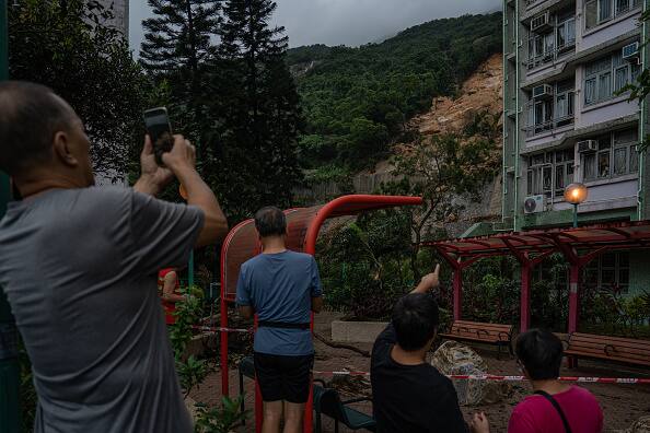 People photograph a landslip after heavy rain in Hong Kong, China. The heavy rains have caused extensive floods and landslides, as well as traffic closures and flooding in malls and train stations. (Source: Getty)