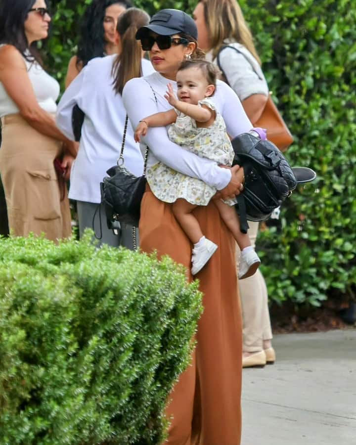 Priyanka had a black handbag slung over her shoulder and was dressed in wide-legged brown bottoms and a white T-shirt.