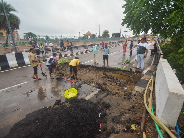 Workers engaged in repairing a road which was damaged due to heavy rainfall, in Lucknow, Uttar Pradesh on Monday. (Source: PTI)